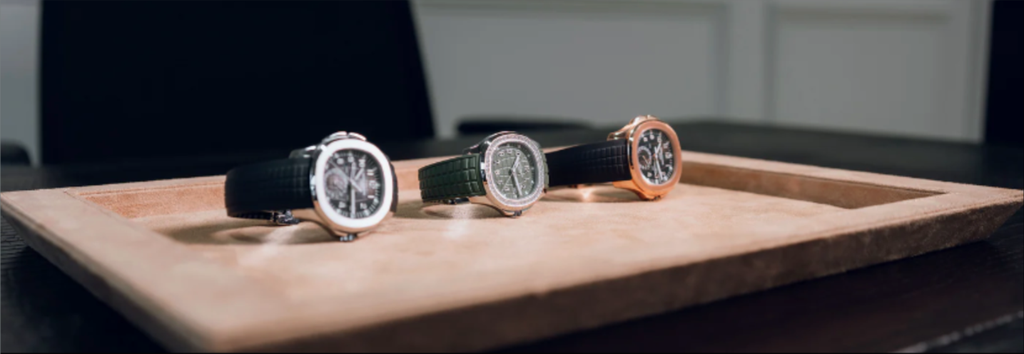 Three watches on a wooden tray with a blurred background