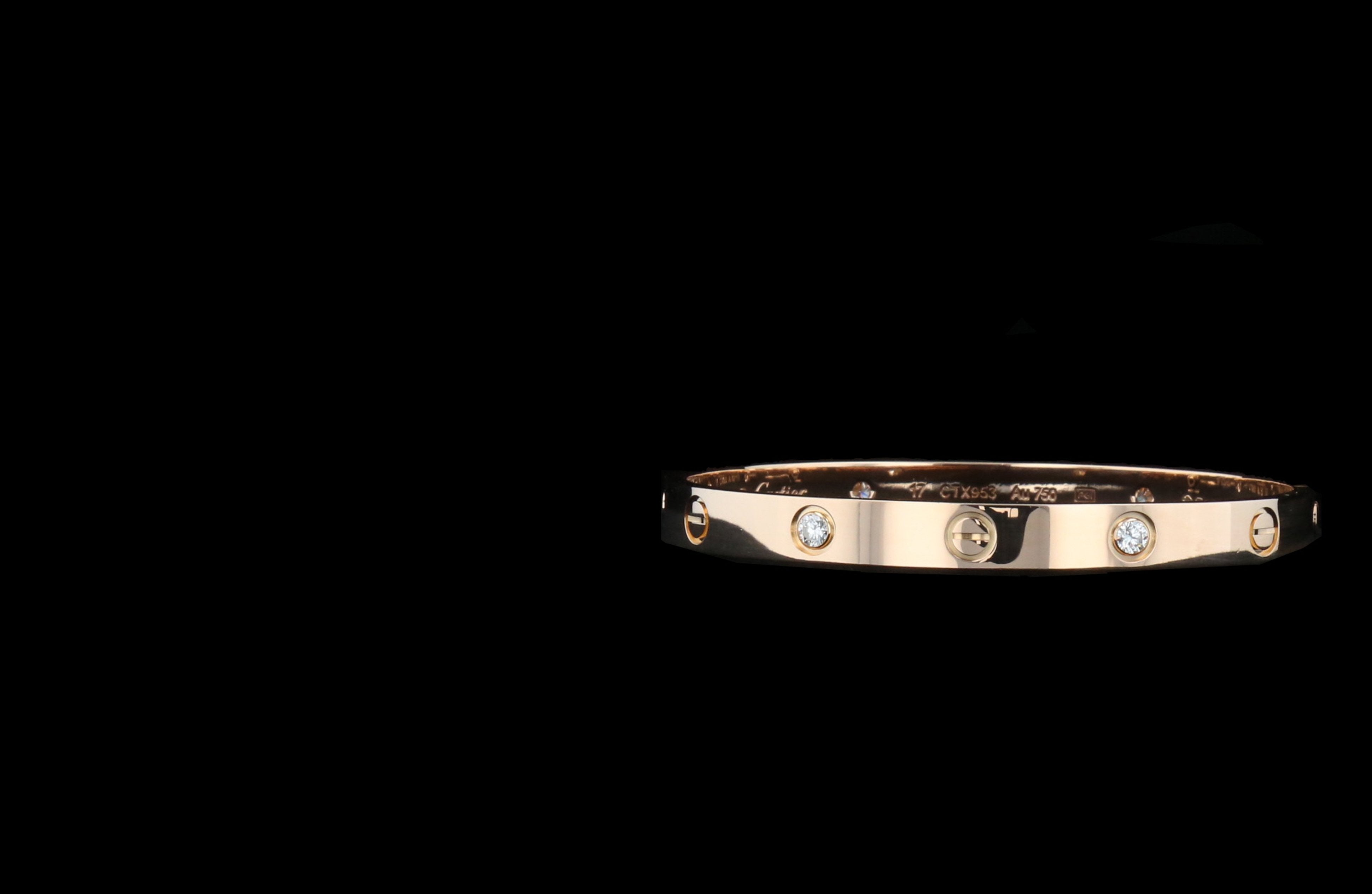 A gold bracelet with diamond accents embedded evenly around its band is set against a black background, exuding elegance and luxury.